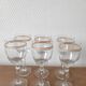 Set of 6 glasses with gold band decorations.