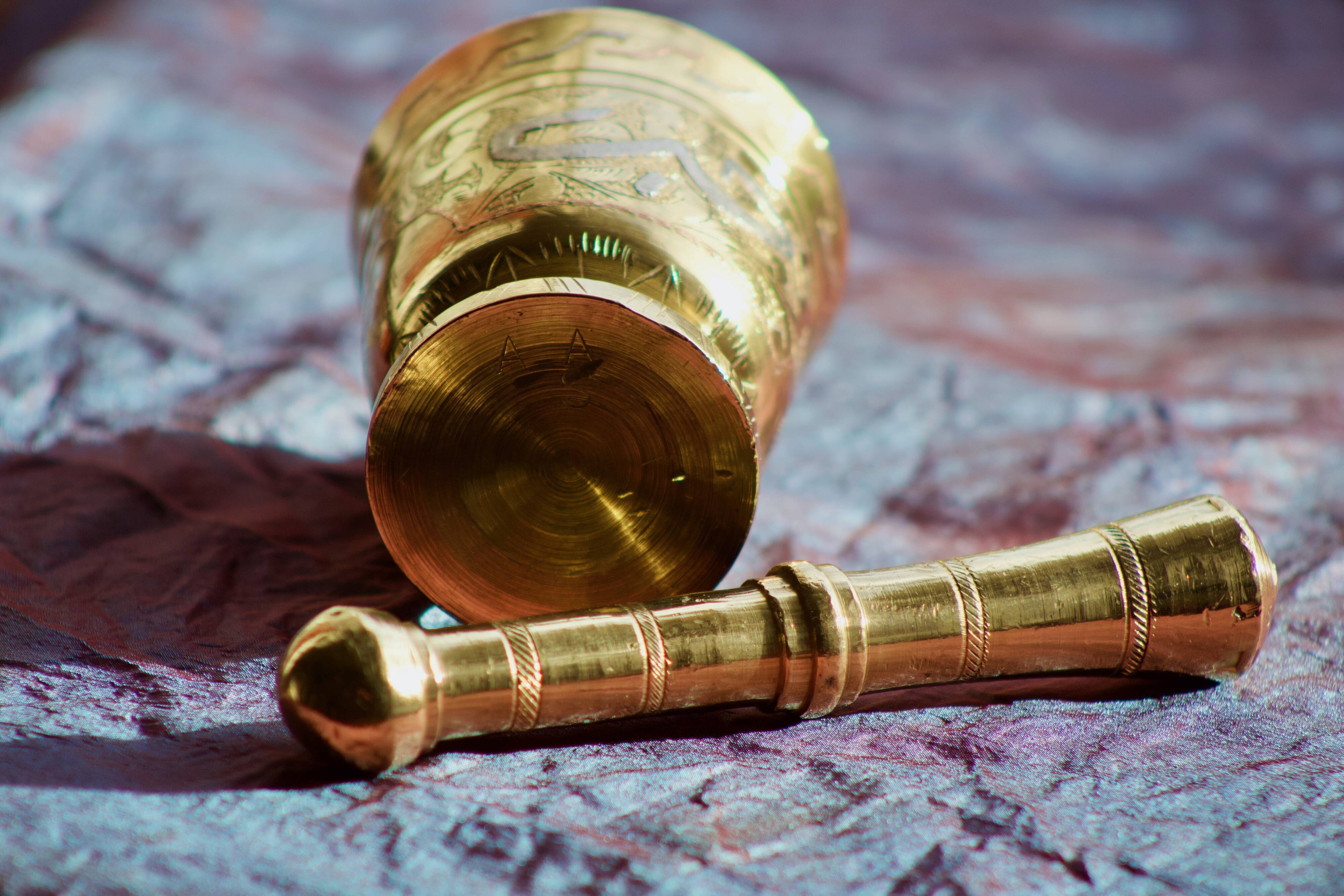 Mortar and its brass pestle with oriental gold and silver motifs