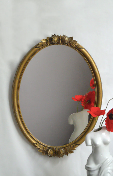 Oval mirror in gilded wood