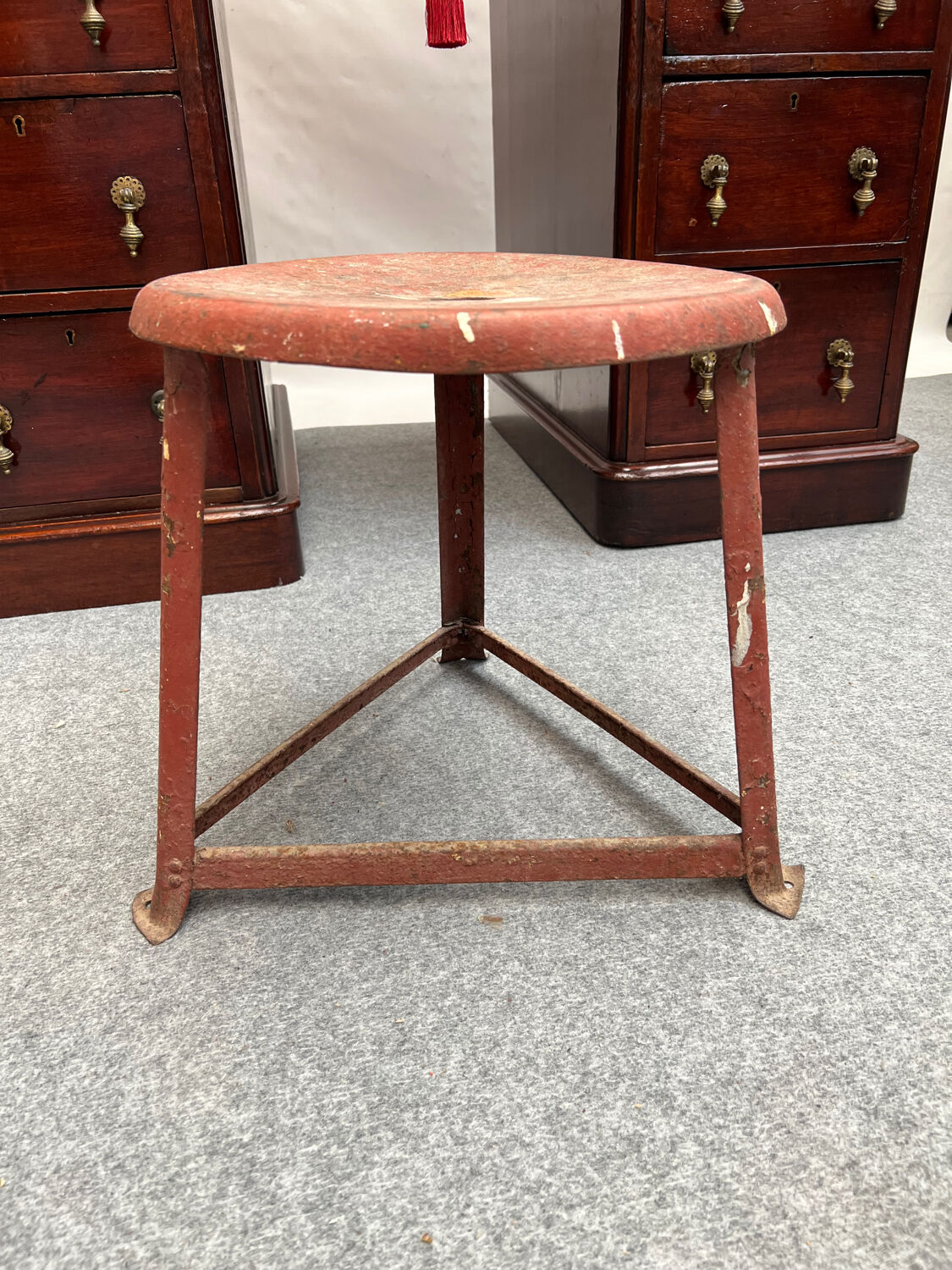 Red tripod industrial metal stool