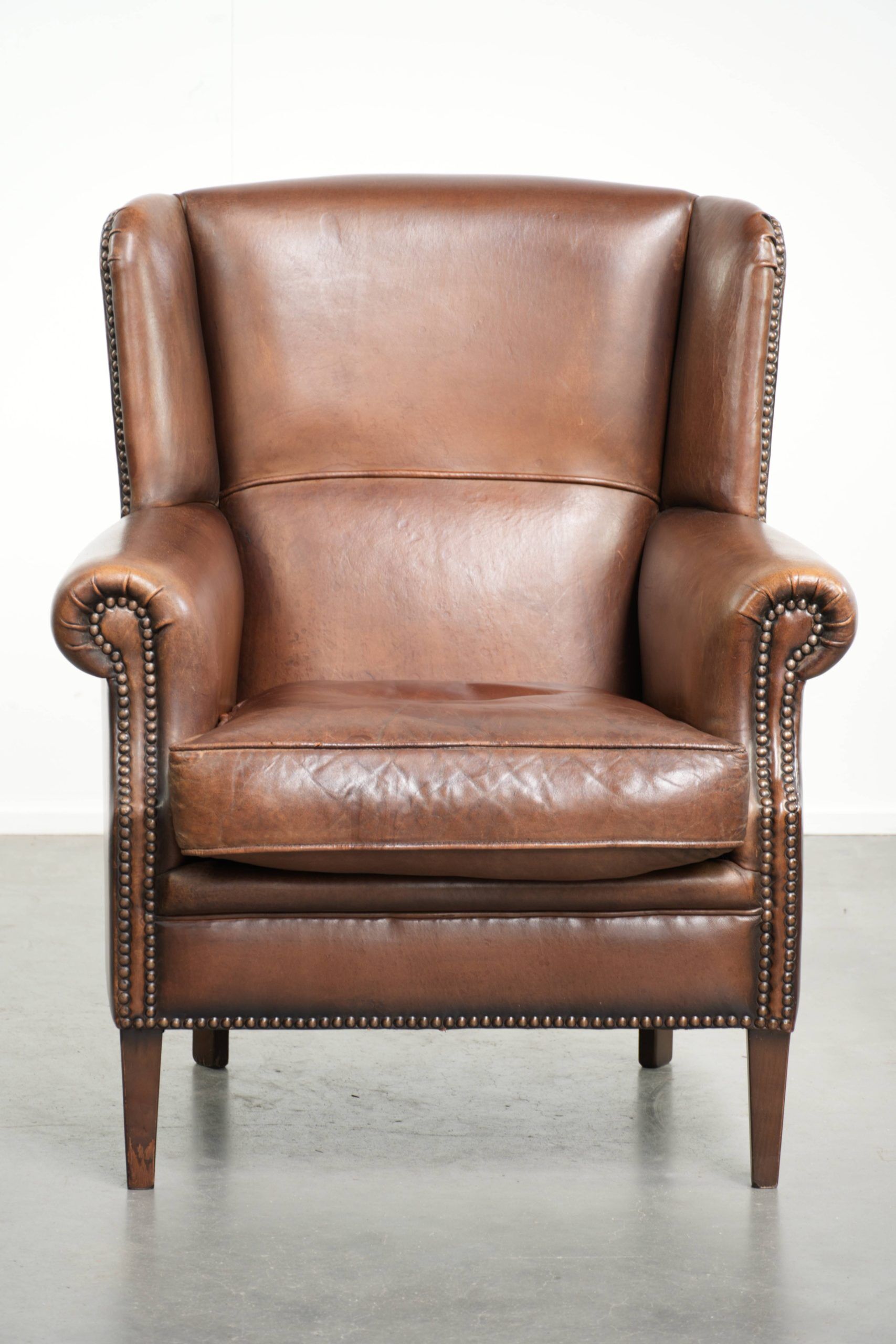 Subtle dark brown sheepskin wingback armchair with a timeless look subtle