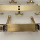 Three vintage 1960s gold coat racks with 4, 3 and 2 hooks