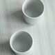 2 tasses en porcelaine avec supports en métal et petites cuillères.