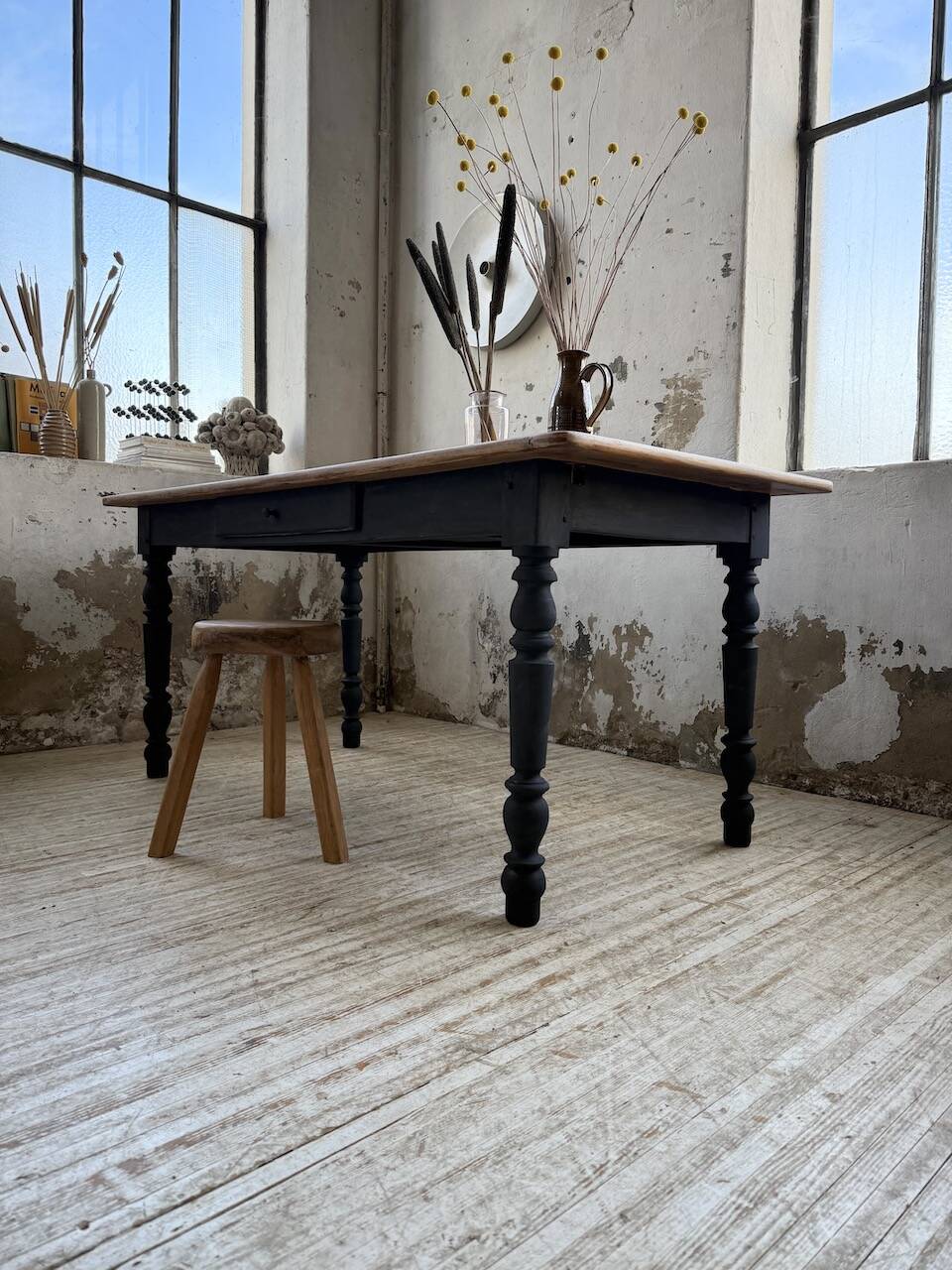 Oak farmhouse table with turned black legs.