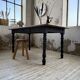 Oak farmhouse table with turned black legs.