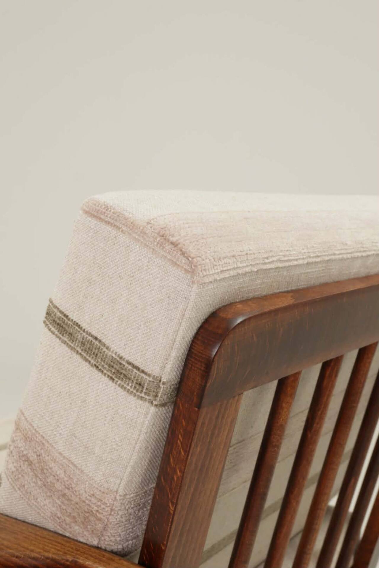Fauteuil vintage avec des coussins en tissu naturel rayé.