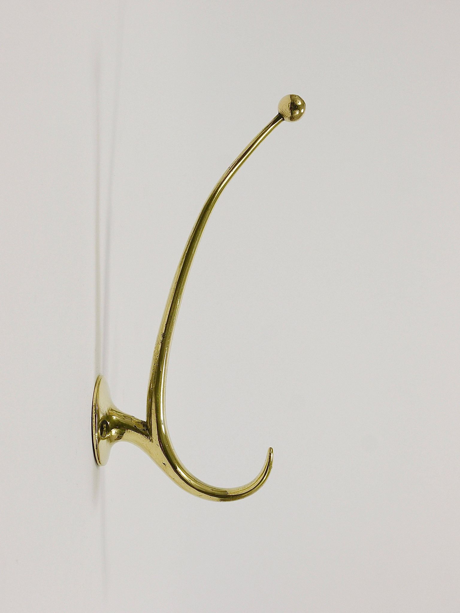 Two curved wall coat racks in brass by Franz Hagenauer, Vienna, mid-20th century, 1950s.