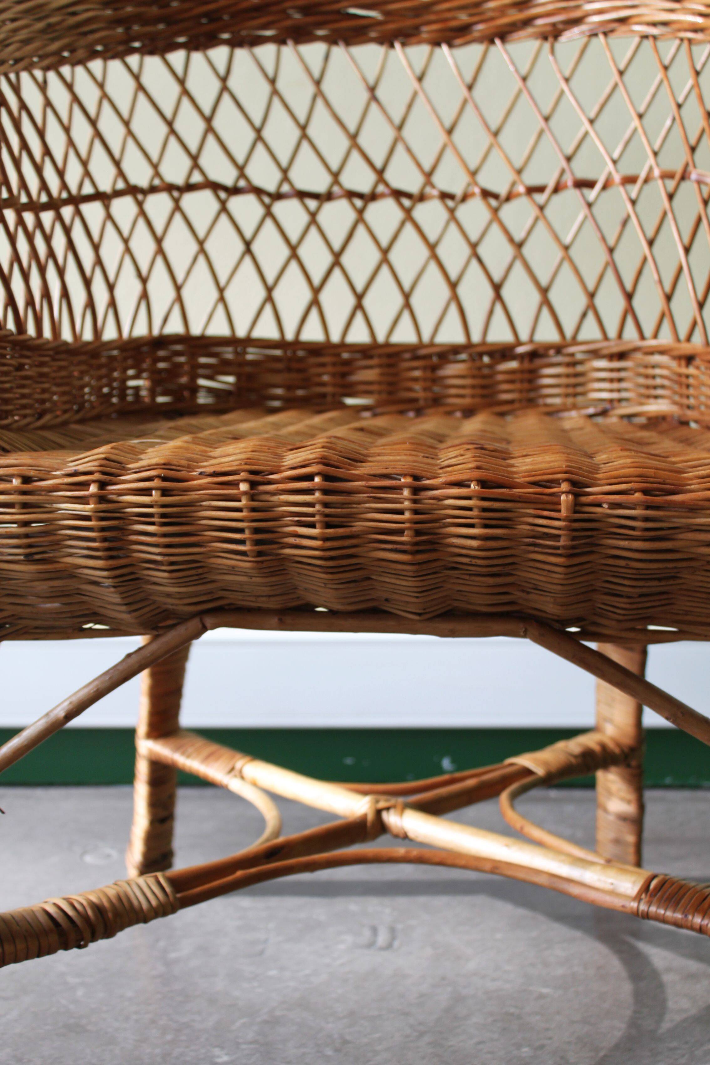 Woven rattan armchair with armrests.