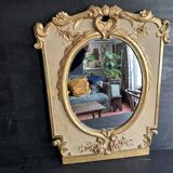 Napoleon III mirror in carved gilded wood, oval mercury glass.