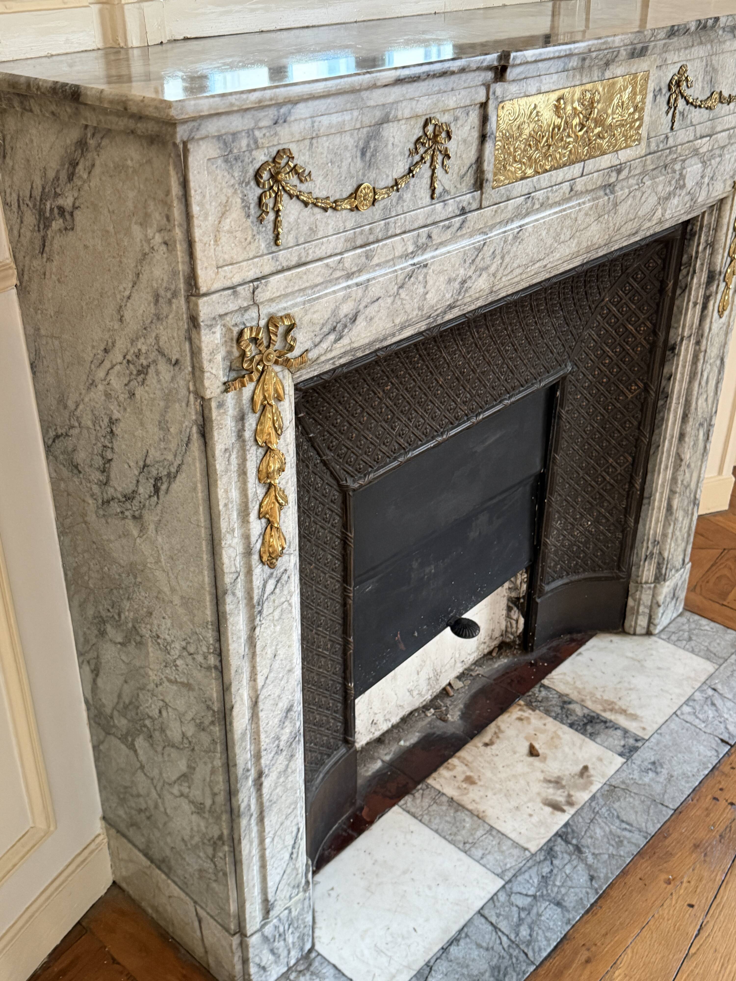 Louis XVI fireplace in veined grey marble with original gilded bronzes from the 19th century.
