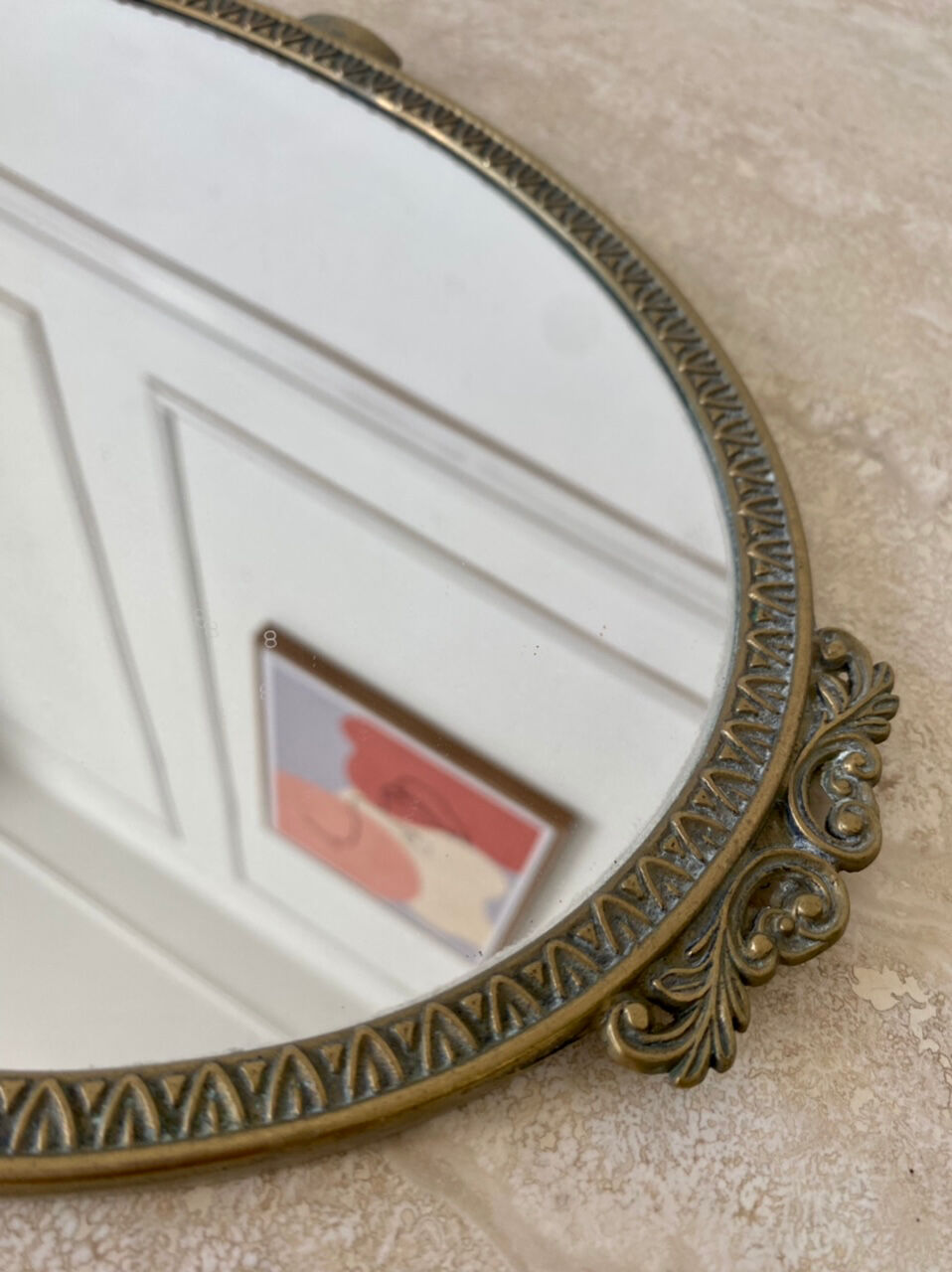 Oval mirror in gilded brass