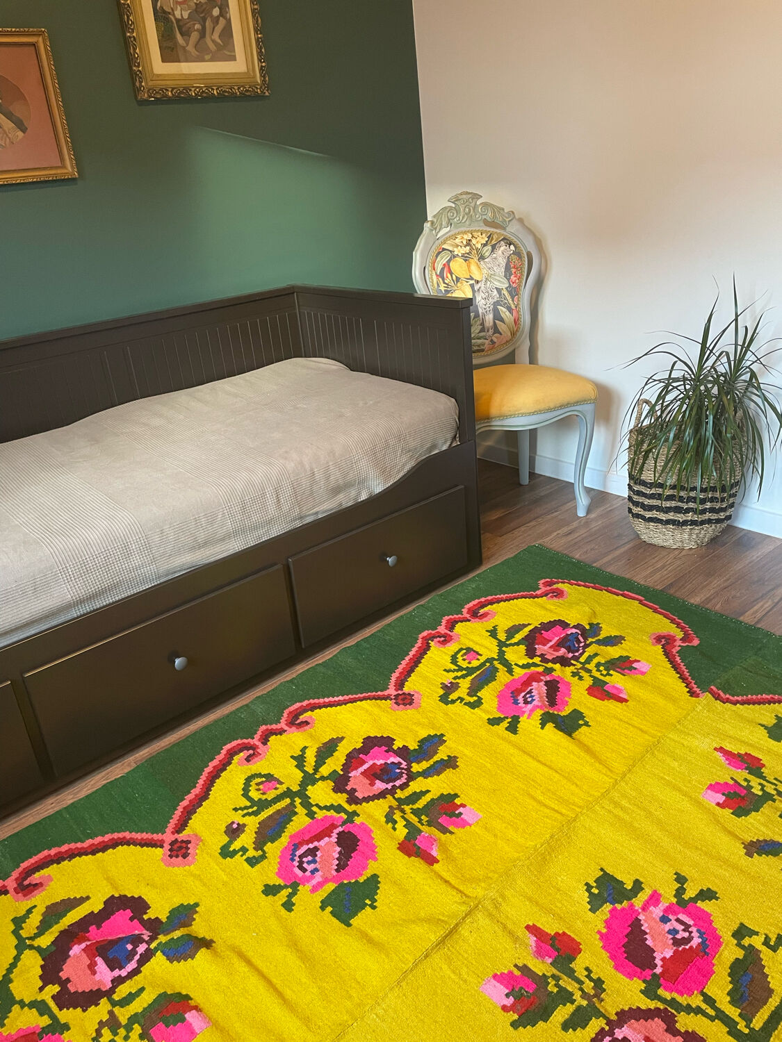 Vintage wool rug with pink flowers on green and yellow background made by hand in Transylvania