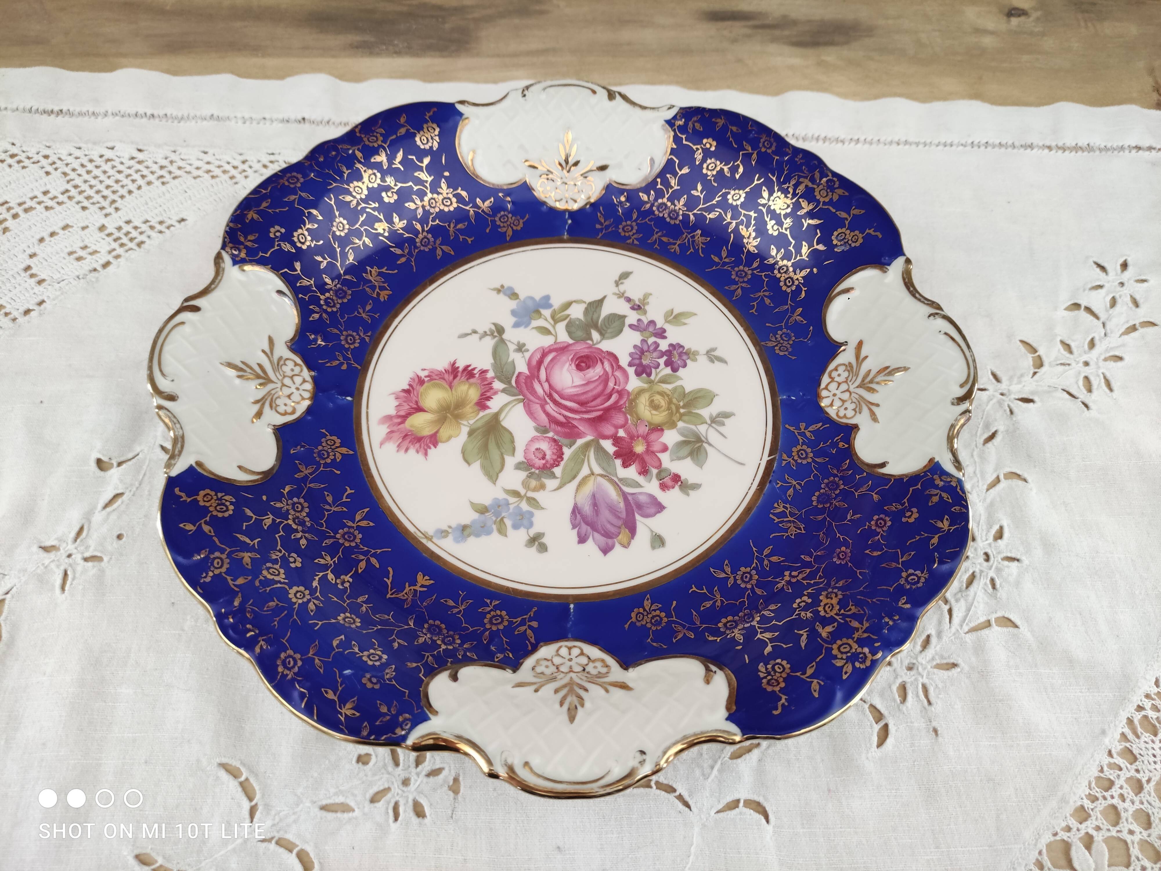 Plat rond creux en porcelaine allemande bleu nuit et motifs floraux polychromes et dorés