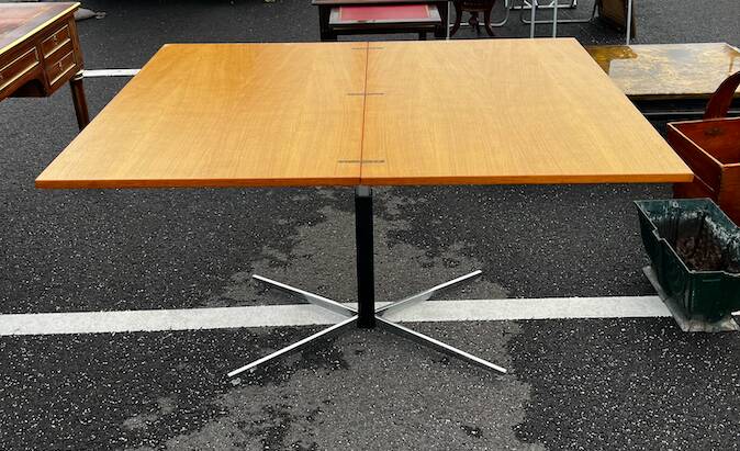 Table rises and lowers in light wood and metal.