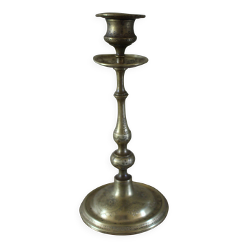 Brass candle holder with flowers and round shape.