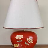 large vintage ceramic lamp with flower decorations on a red background circa 1980