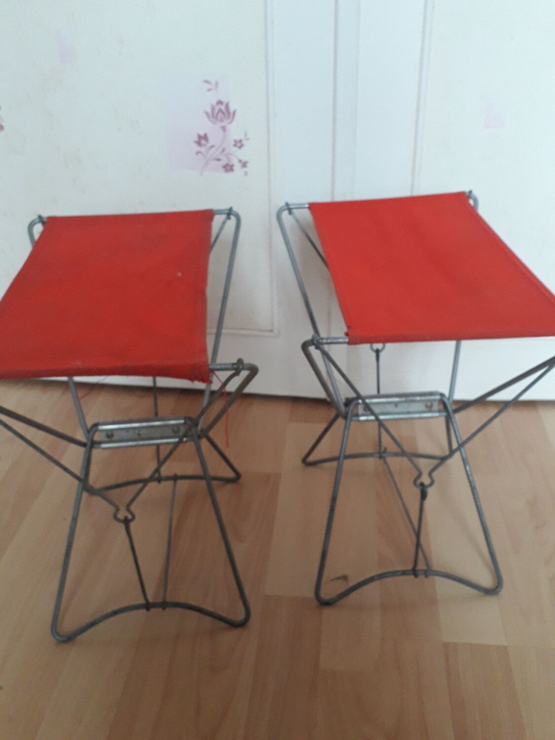 Folding stool in red canvas but unstitched on one side