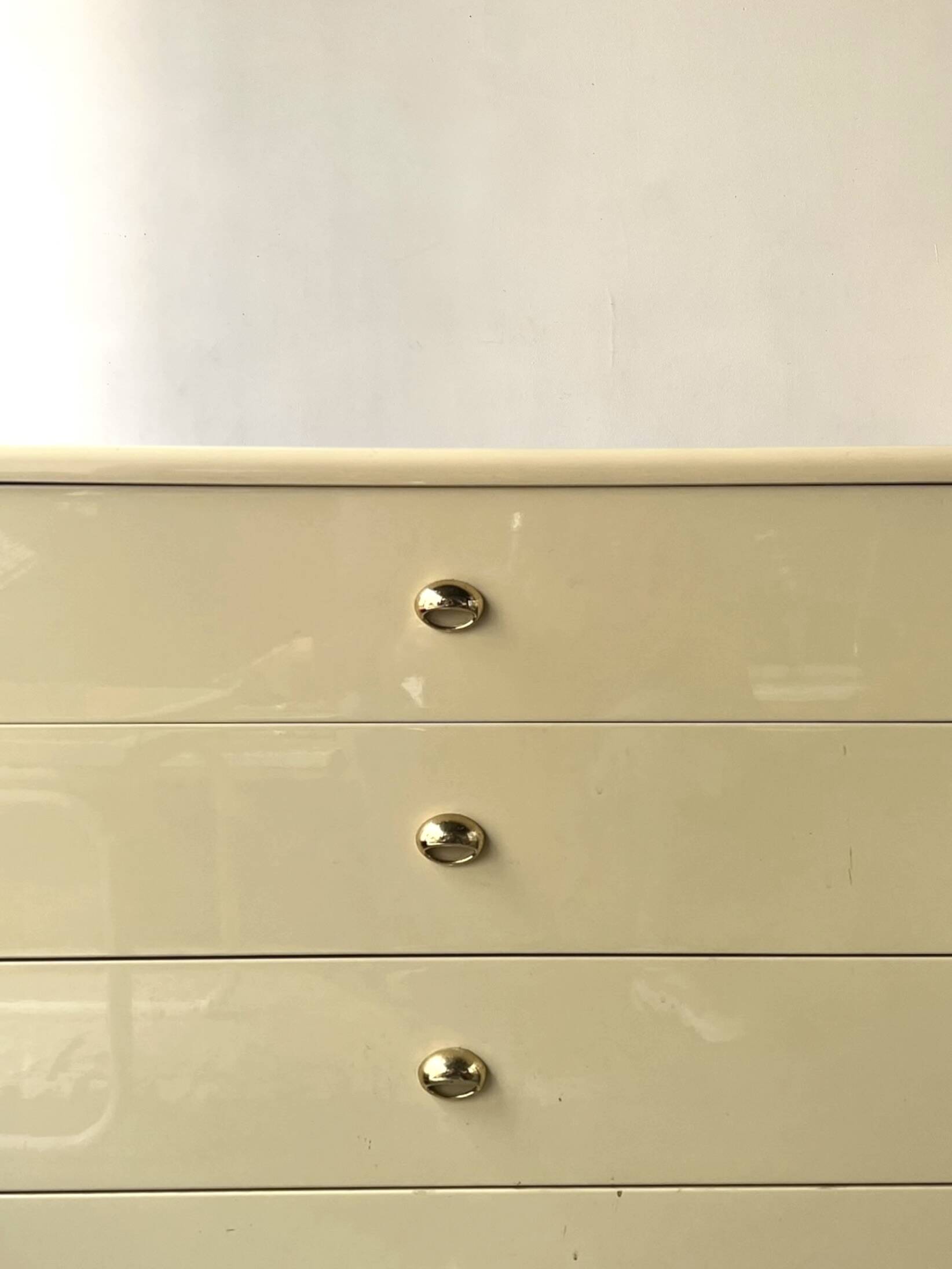 Commode type sideboard with 8 drawers, ivory lacquer and brass details, 1970s design.