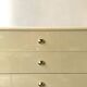 Commode type sideboard with 8 drawers, ivory lacquer and brass details, 1970s design.