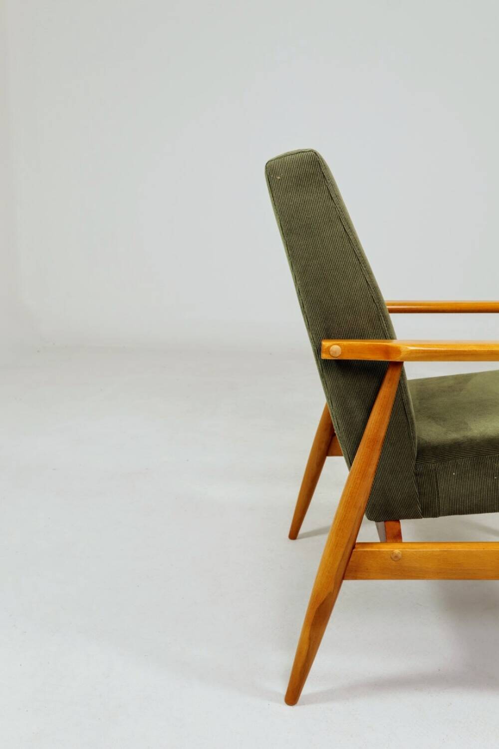 Mid-century modern design armchair in olive green corduroy.