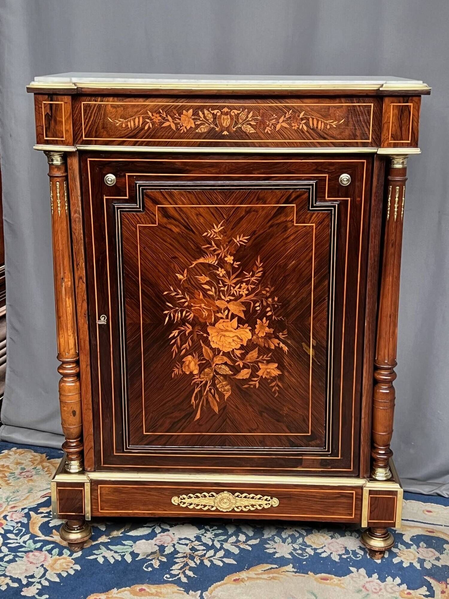 Elegant Napoleon III style commode with fine marquetry, gilded bronze mounts, and a marble top.