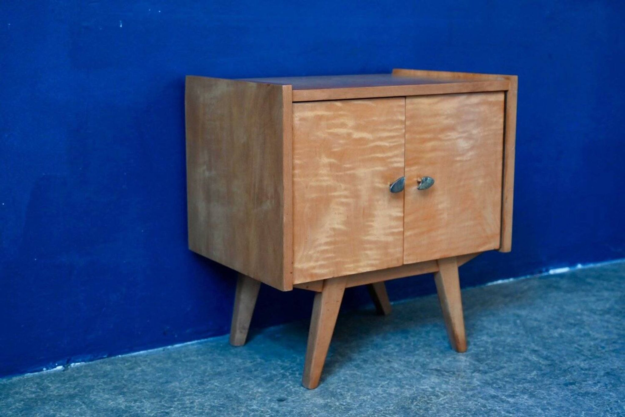 Rockabilly design bedside table with tapered legs.