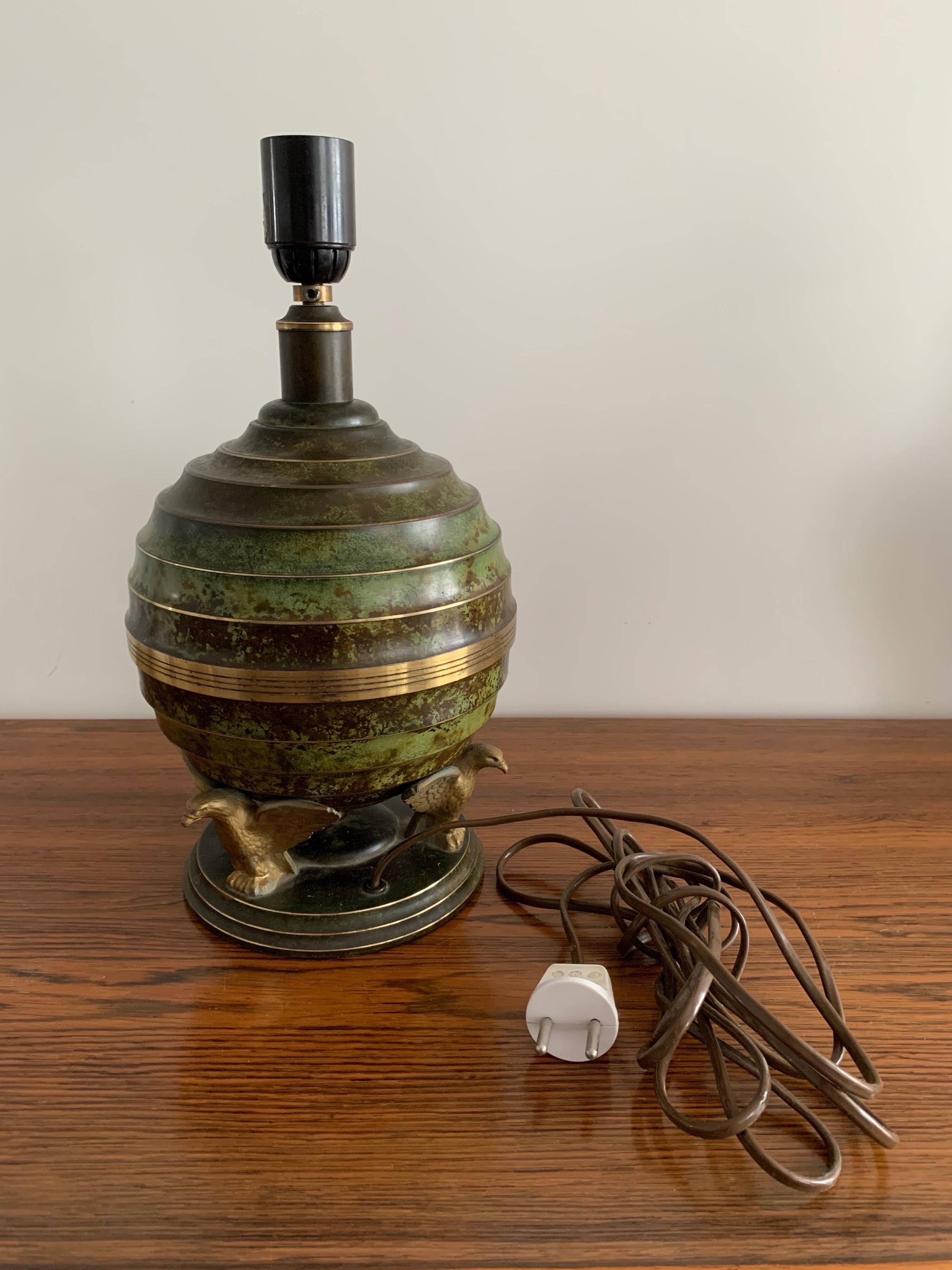 Art Deco table lamp in patinated bronze with eagles holding a globe, France 1940.