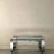 Brushed chrome coffee table with glass, 2 tiers on wheels, 1970s design.