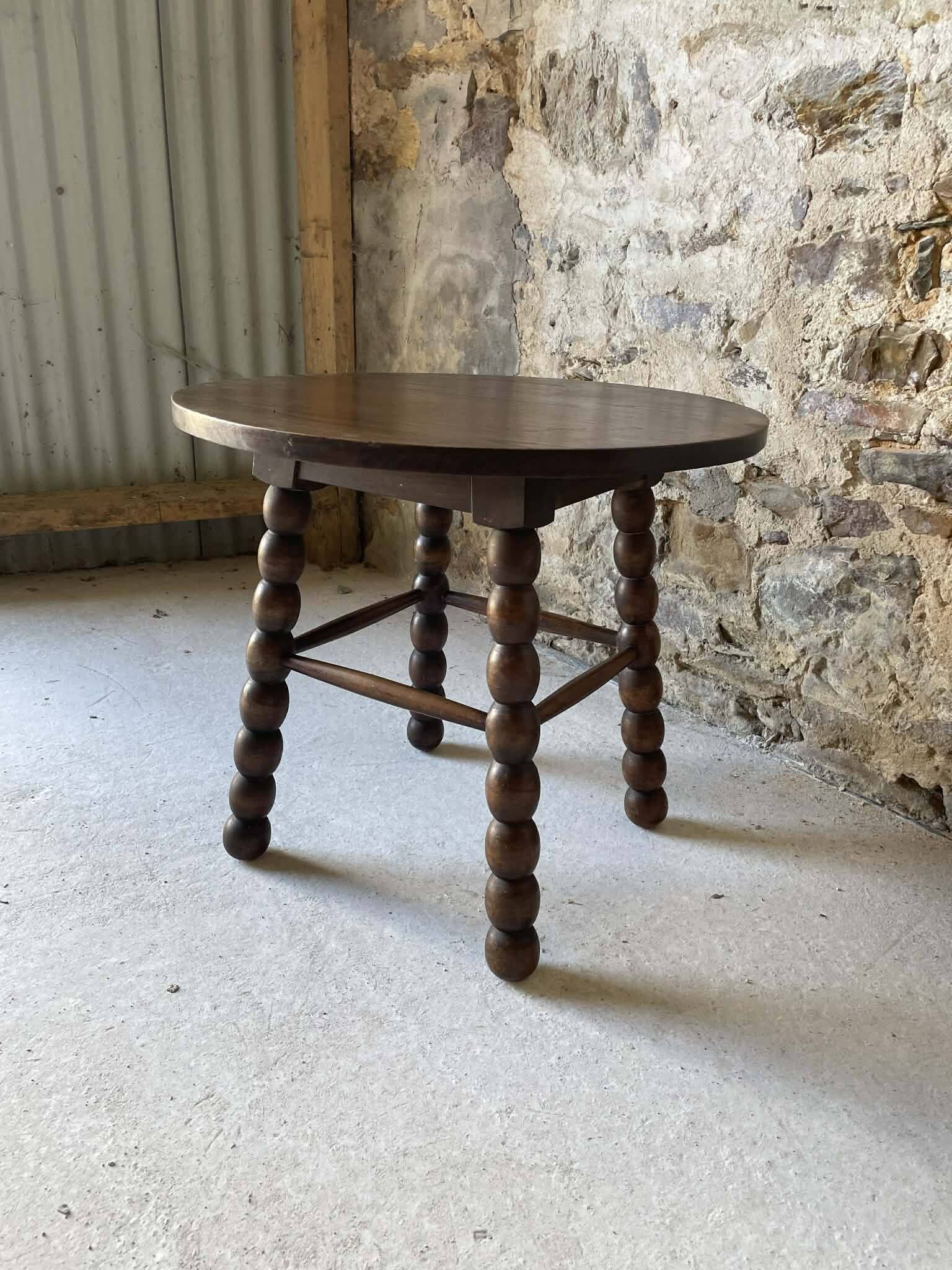 Round wooden coffee table with turned legs.