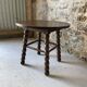 Round wooden coffee table with turned legs.