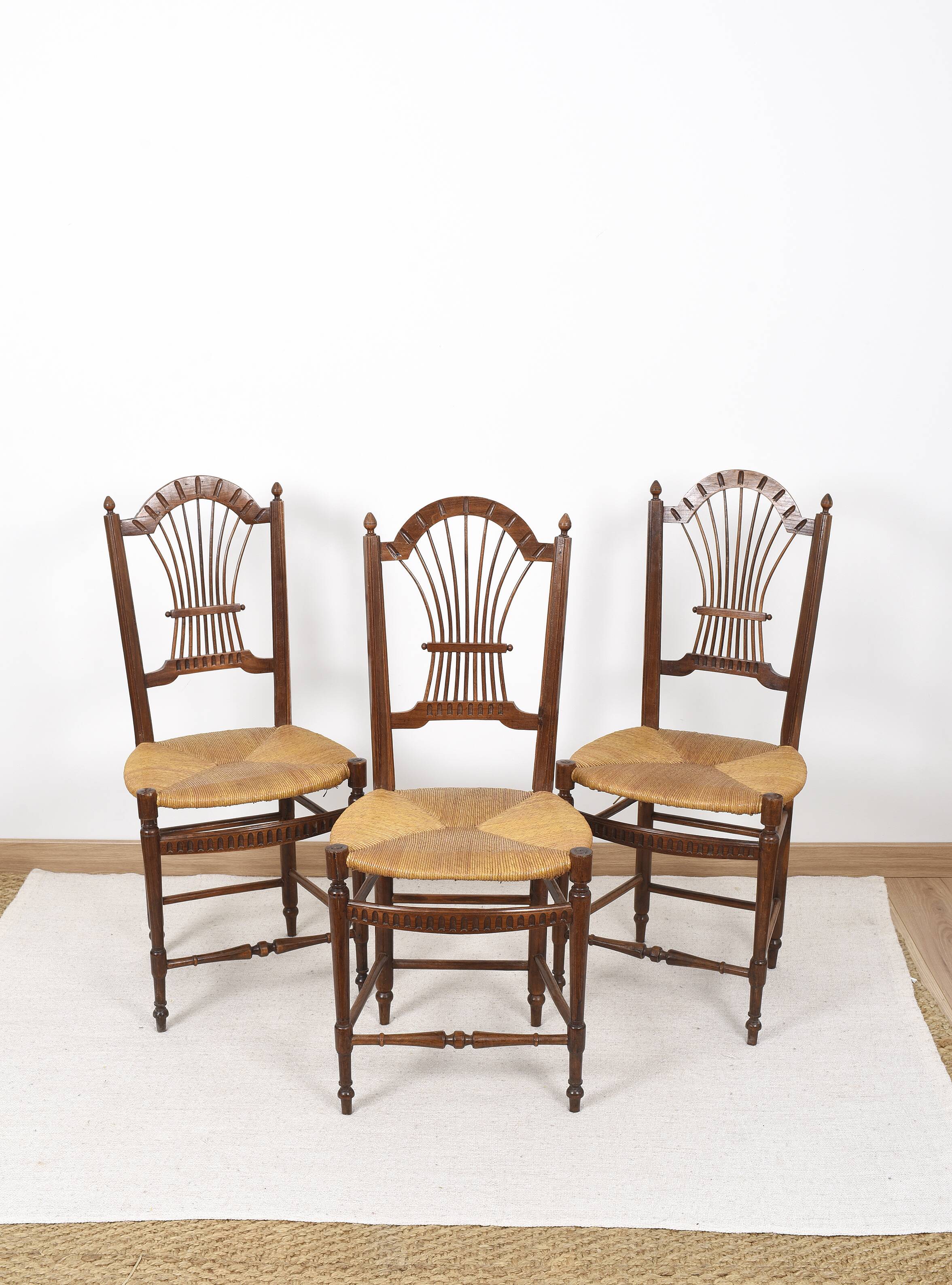 3 wooden and straw chairs, decorated with a sheaf of wheat.