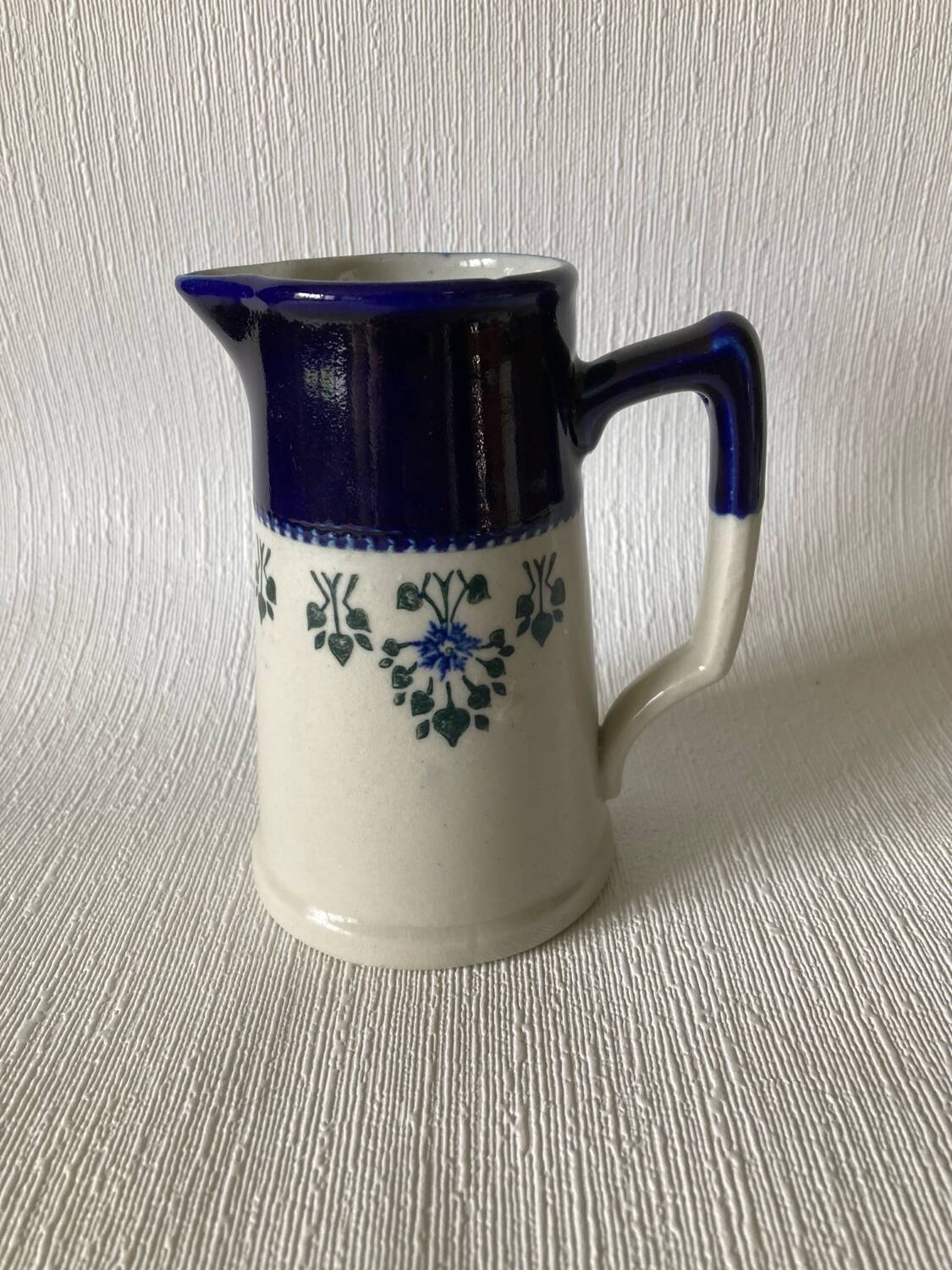 Pichet Saint-Uze en terre d’acier bleu, blanc et à décor floral