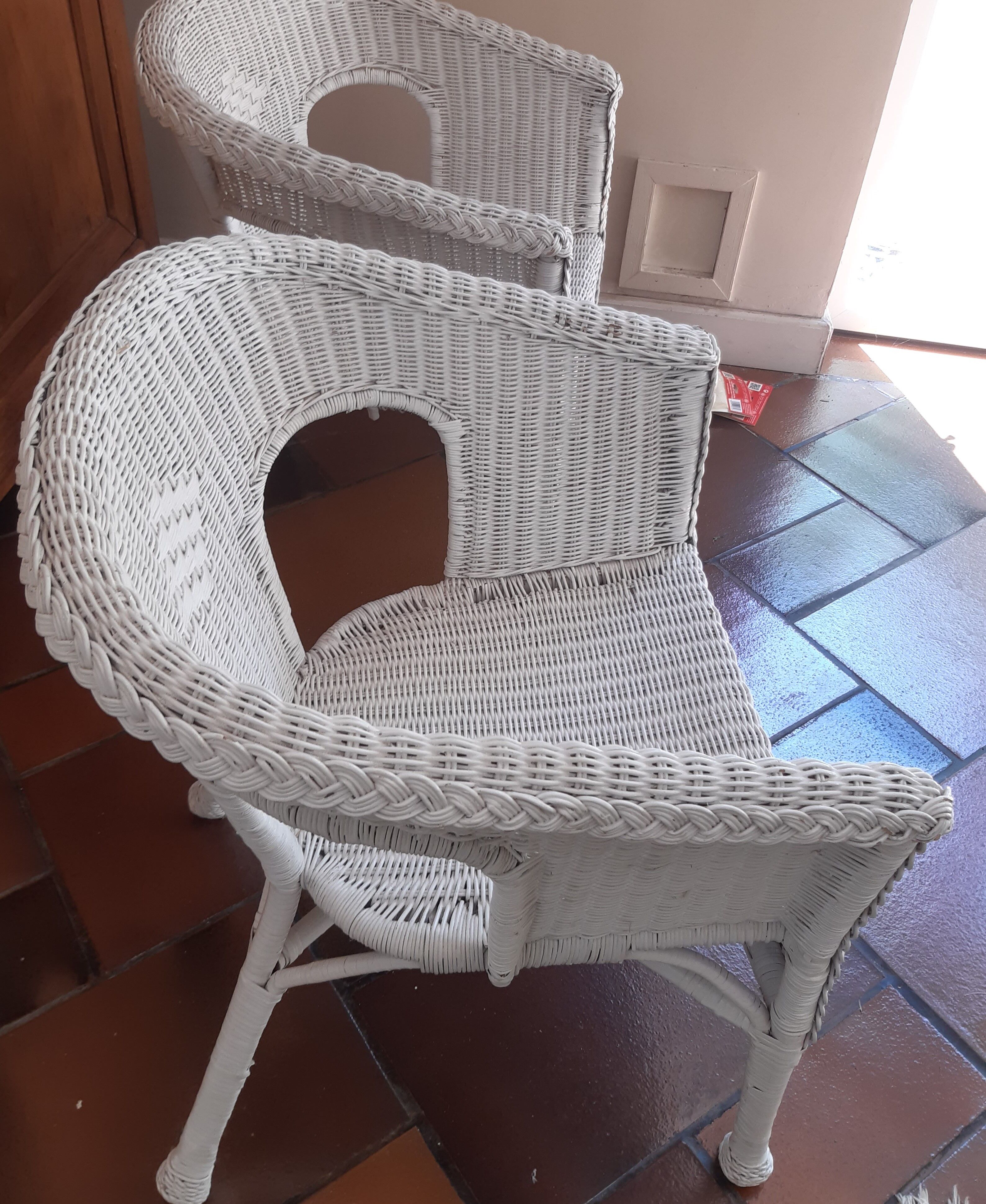 2 white wicker armchairs