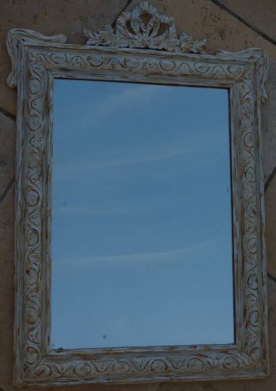 Chic and stylish old mirror with carved wooden frame in limed white and gold