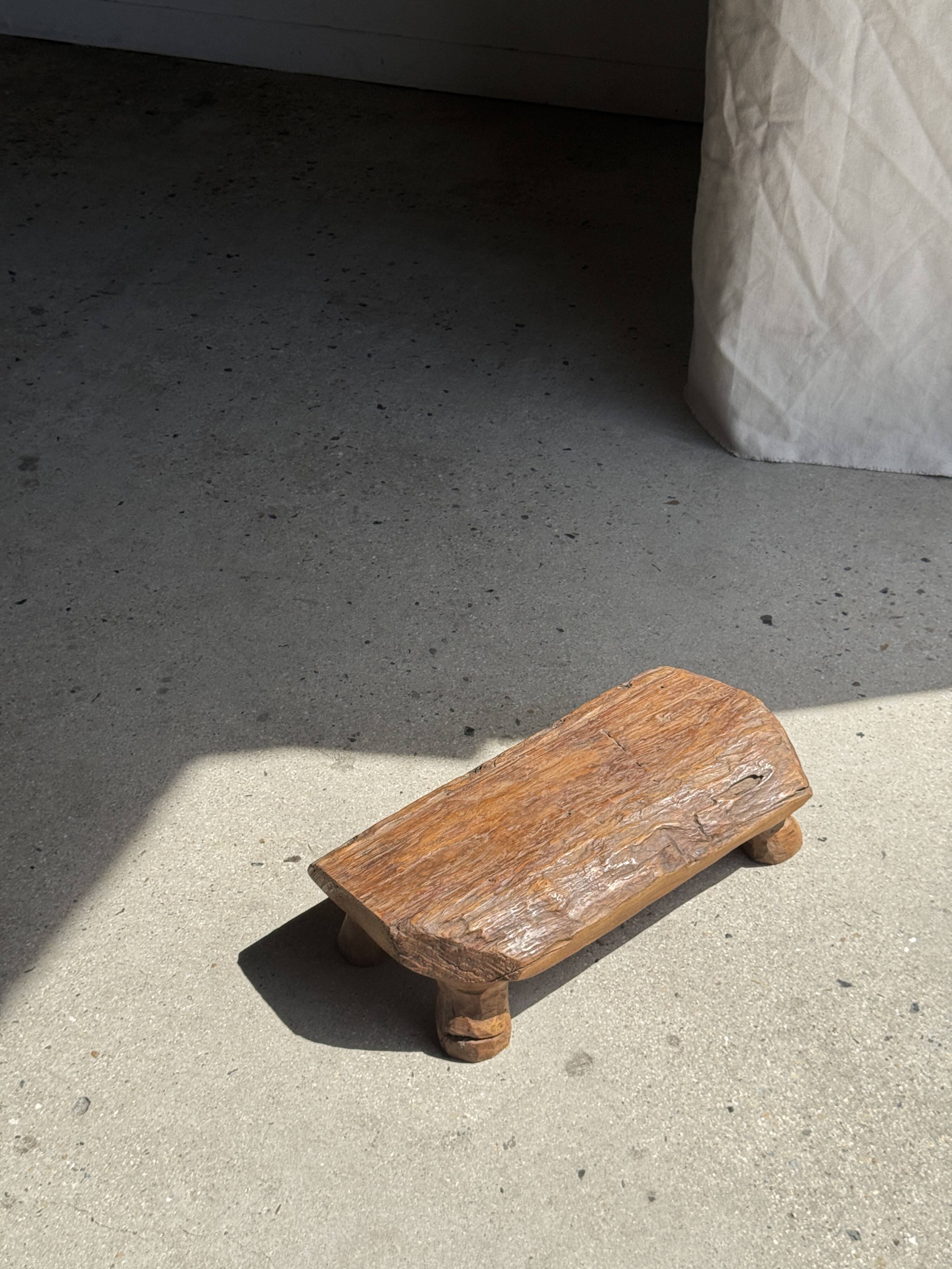Small stool, footrest in blond teak, organic monoxyle with cut corners.