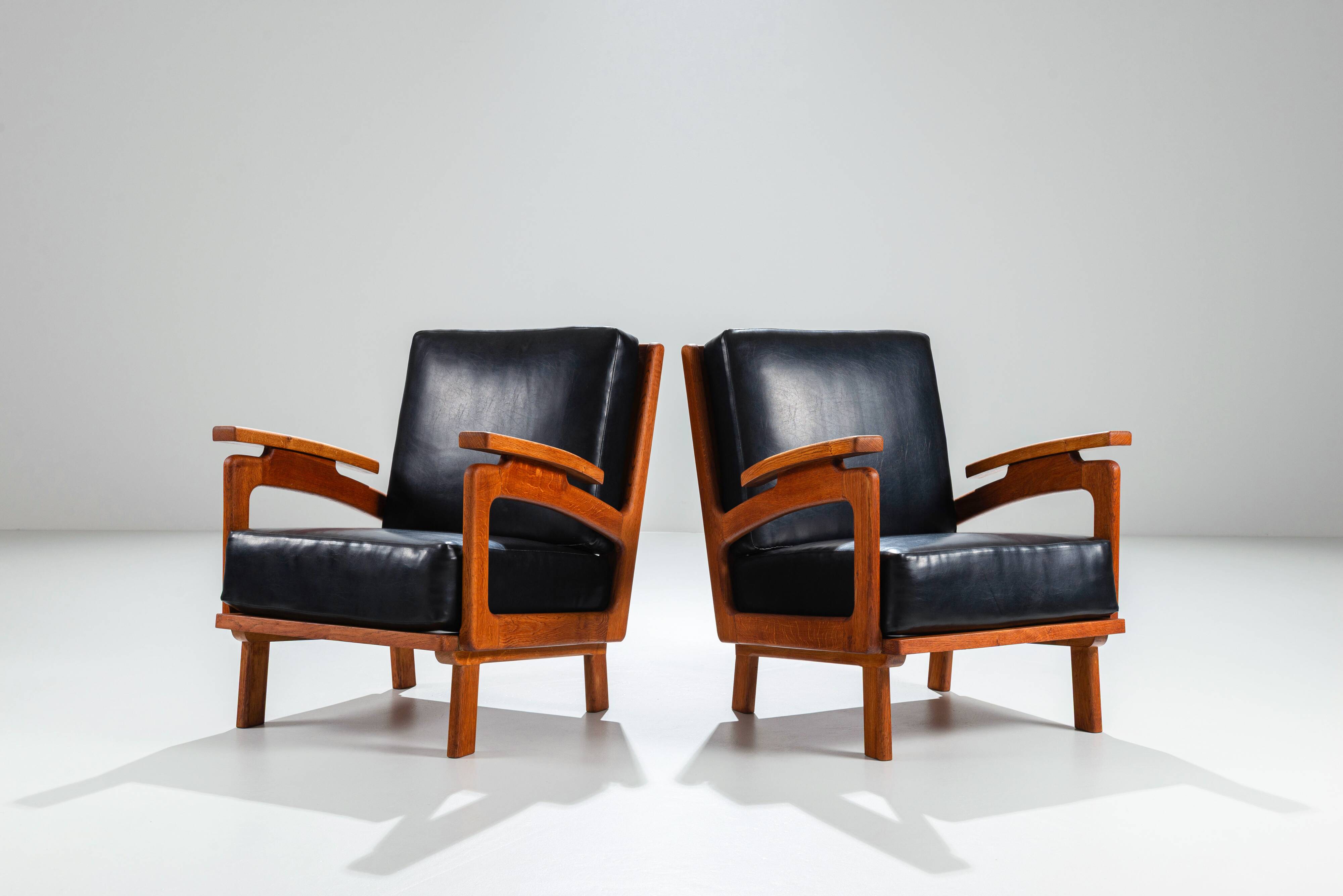 Pair of Belgian lounge chairs in solid oak with leather cushions