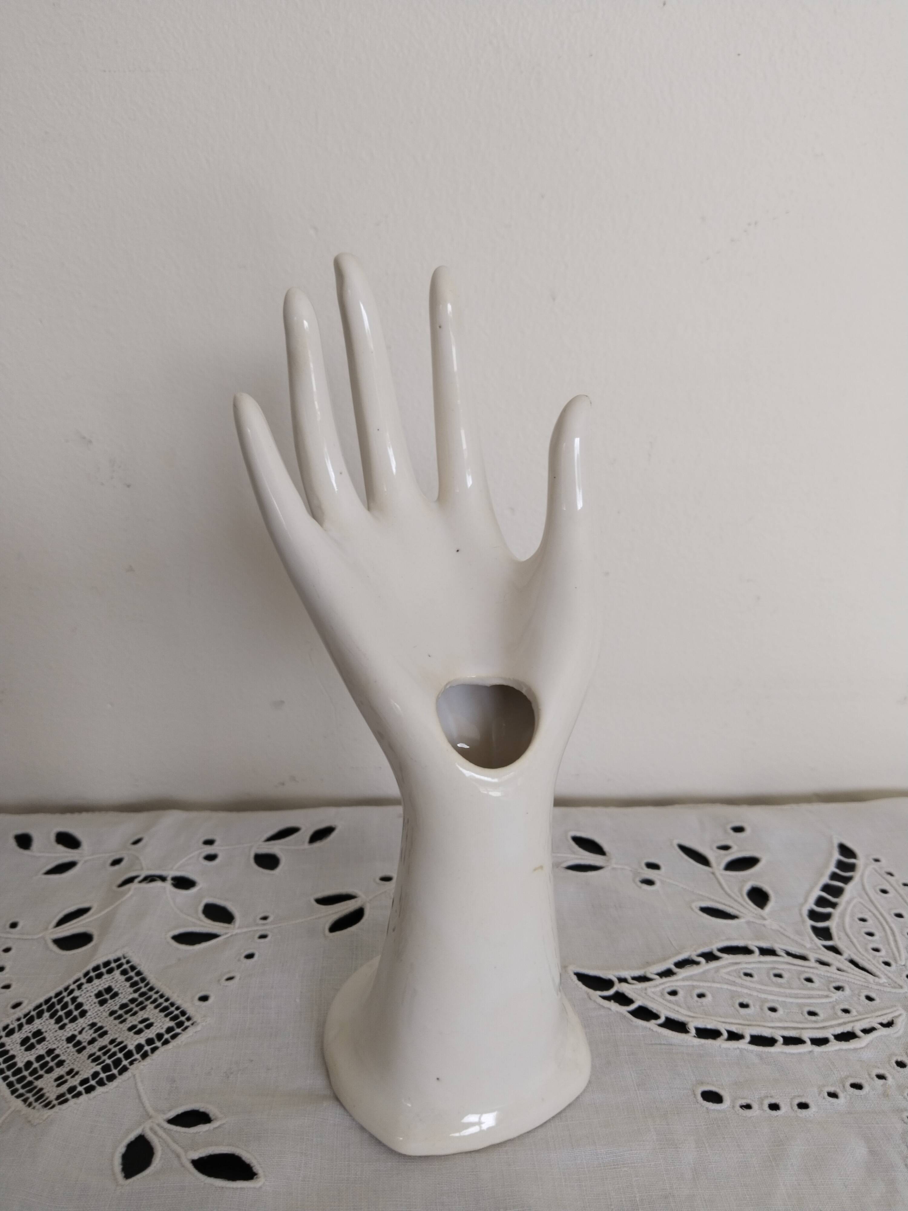 Hand holds white jewelry, ring sizer