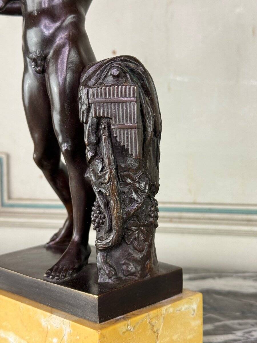 Dionysus on the shoulders of a satyr, bronze after the antique on a yellow Siena base.