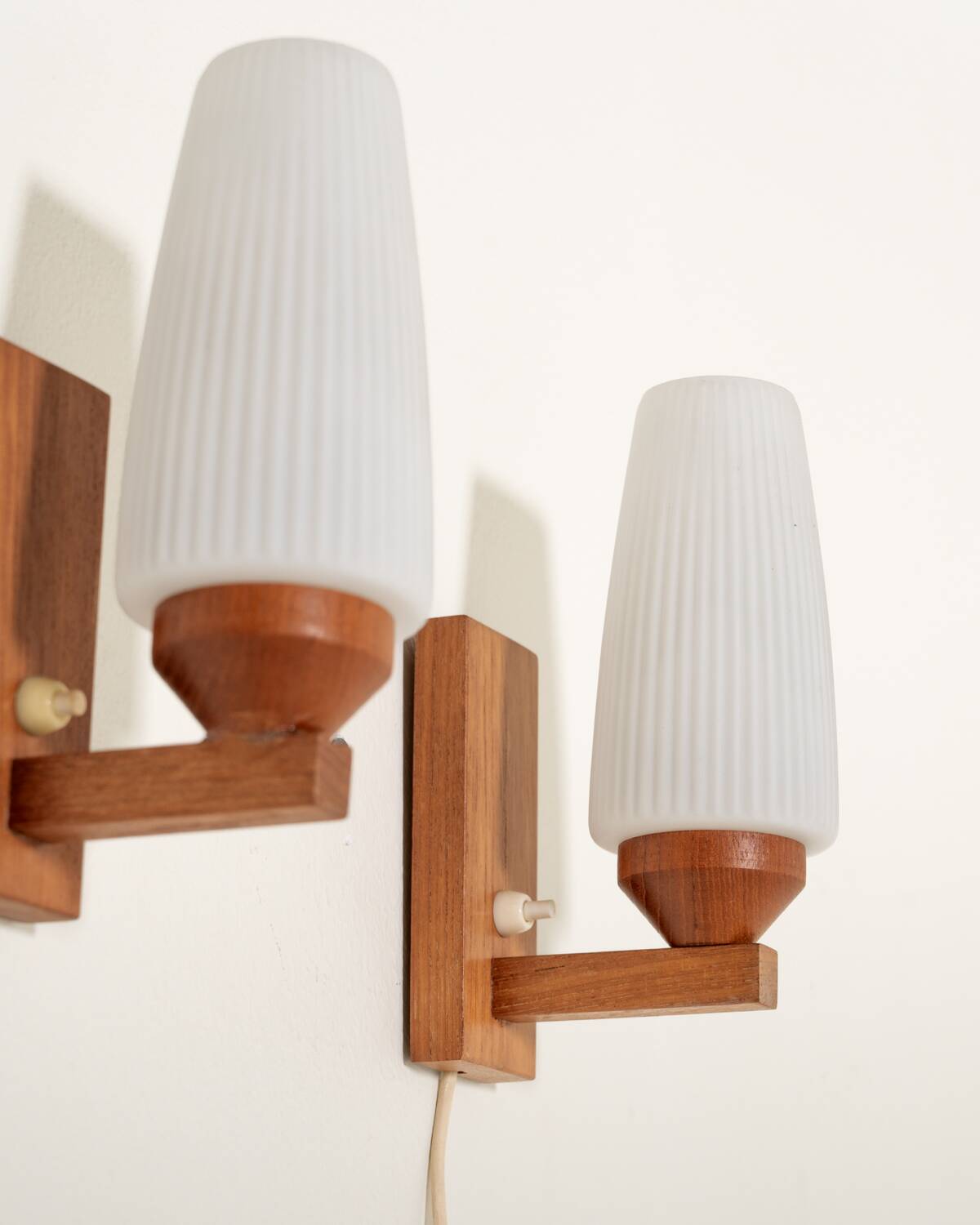 Pair of teak and opaline glass wall lamps, 1950s/1960s