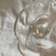 Standing molded glass cup depicting a flower