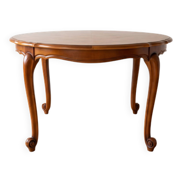 Round extendable dining table in Louis XV style made of wood.