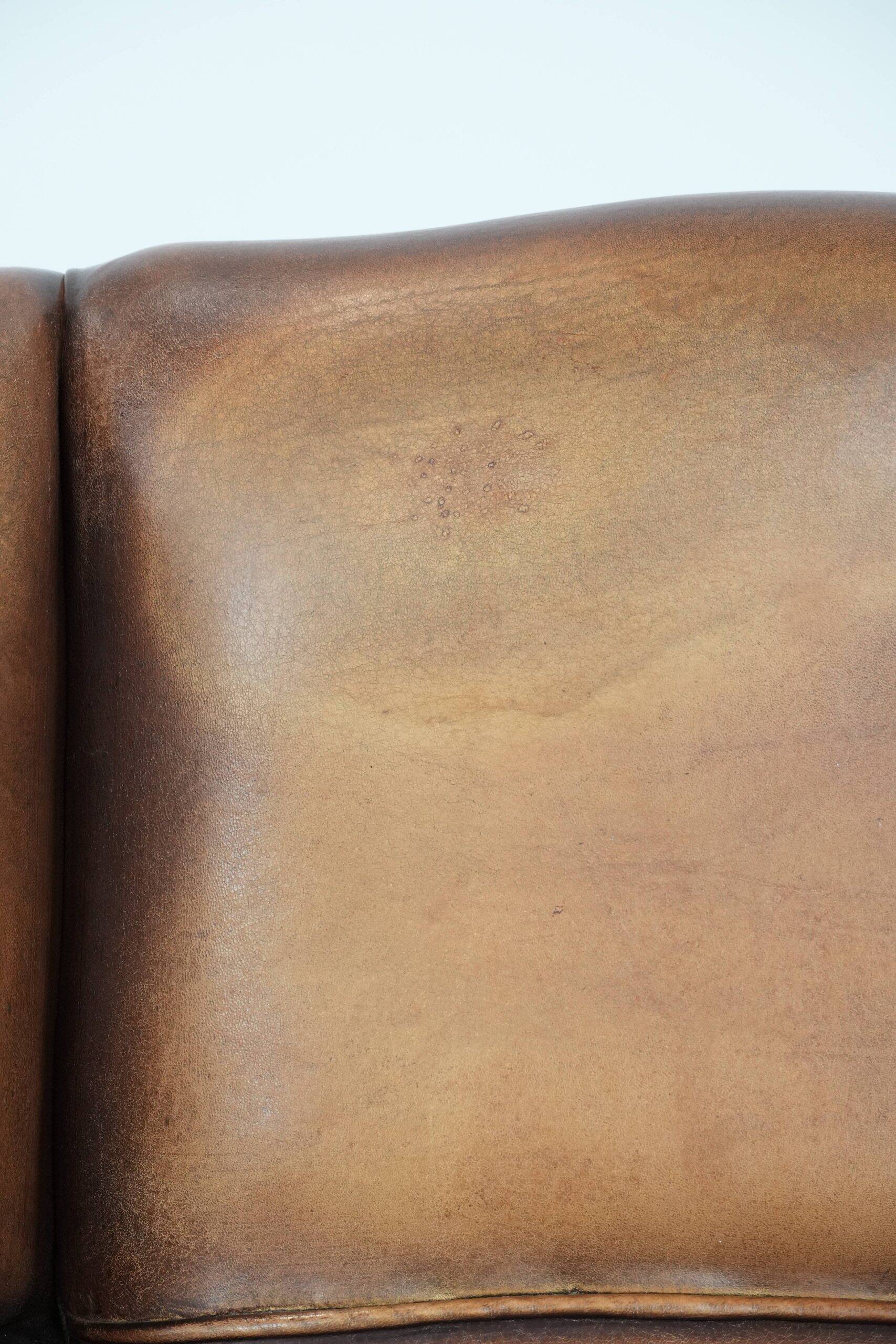 Fauteuil à oreilles en cuir de mouton charmant avec des couleurs chaudes.
