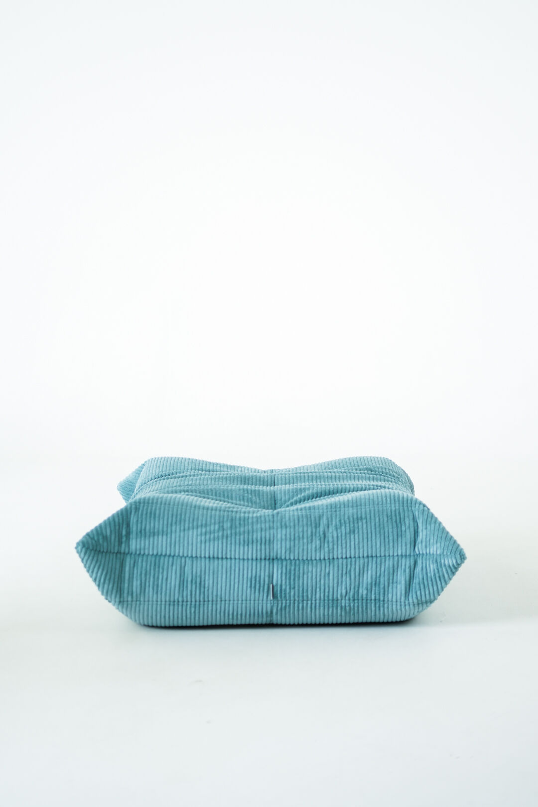 Ensemble de fauteuil et pouf Togo en velours côtelé bleu clair.