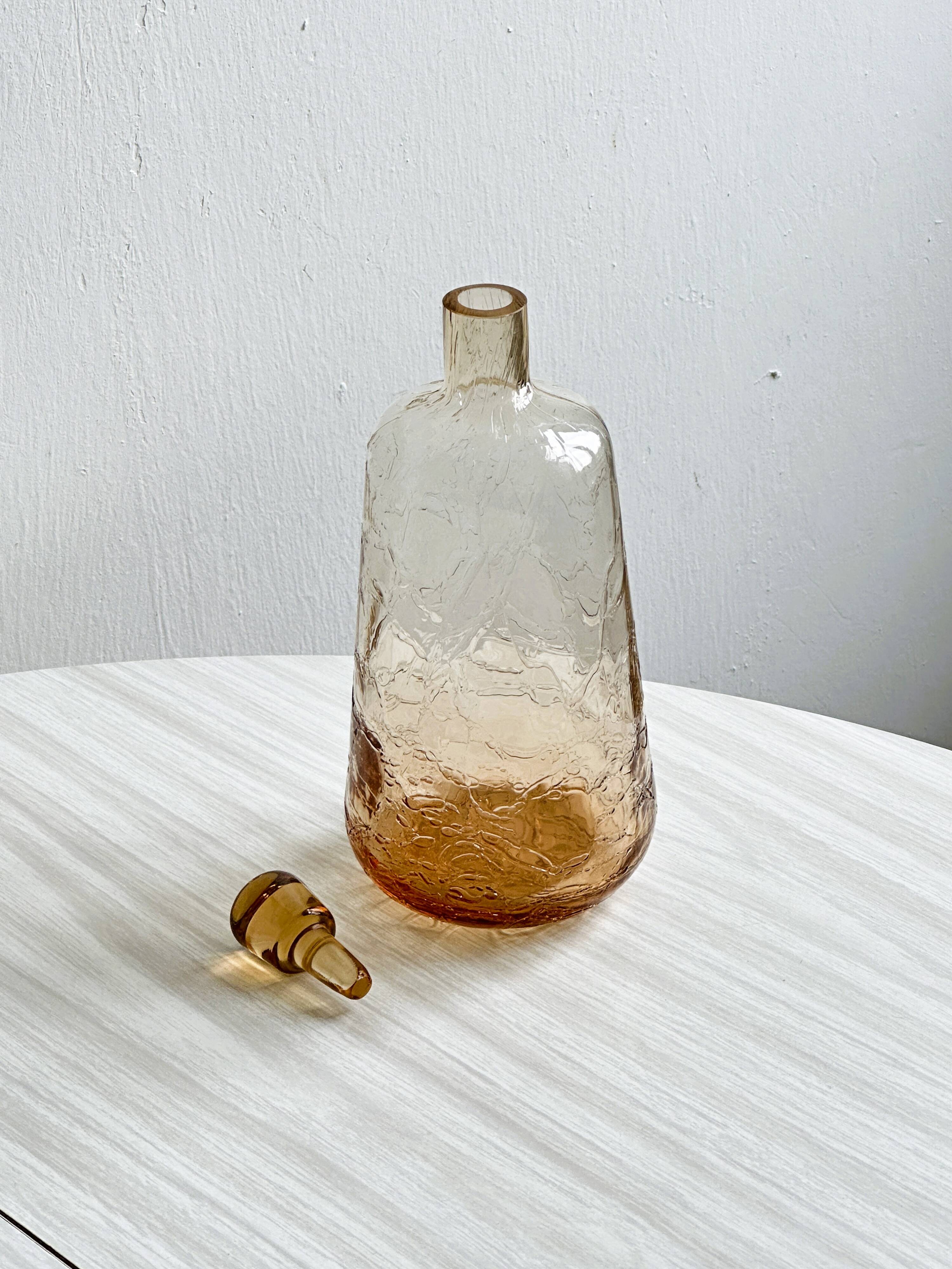 Translucent pinkish iridescent cracked glass bottle.