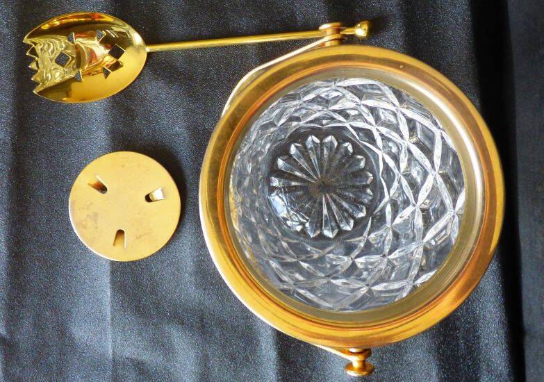 Glass and gold metal ice bucket with its gold metal spoon.