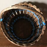 Vintage wooden basket with round handle, blue and black weaving.