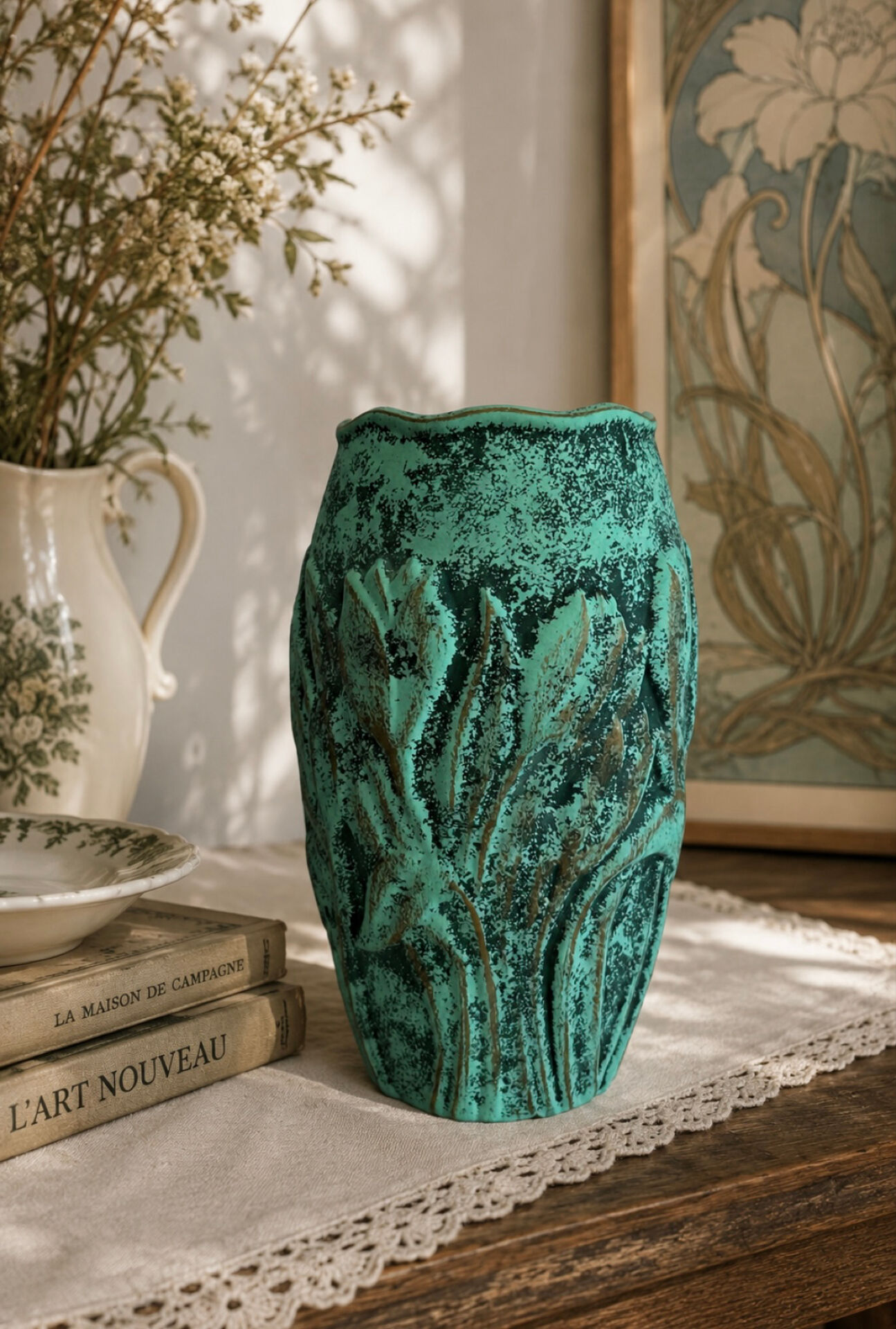 Vintage green patinated ceramic vase with raised floral decoration.