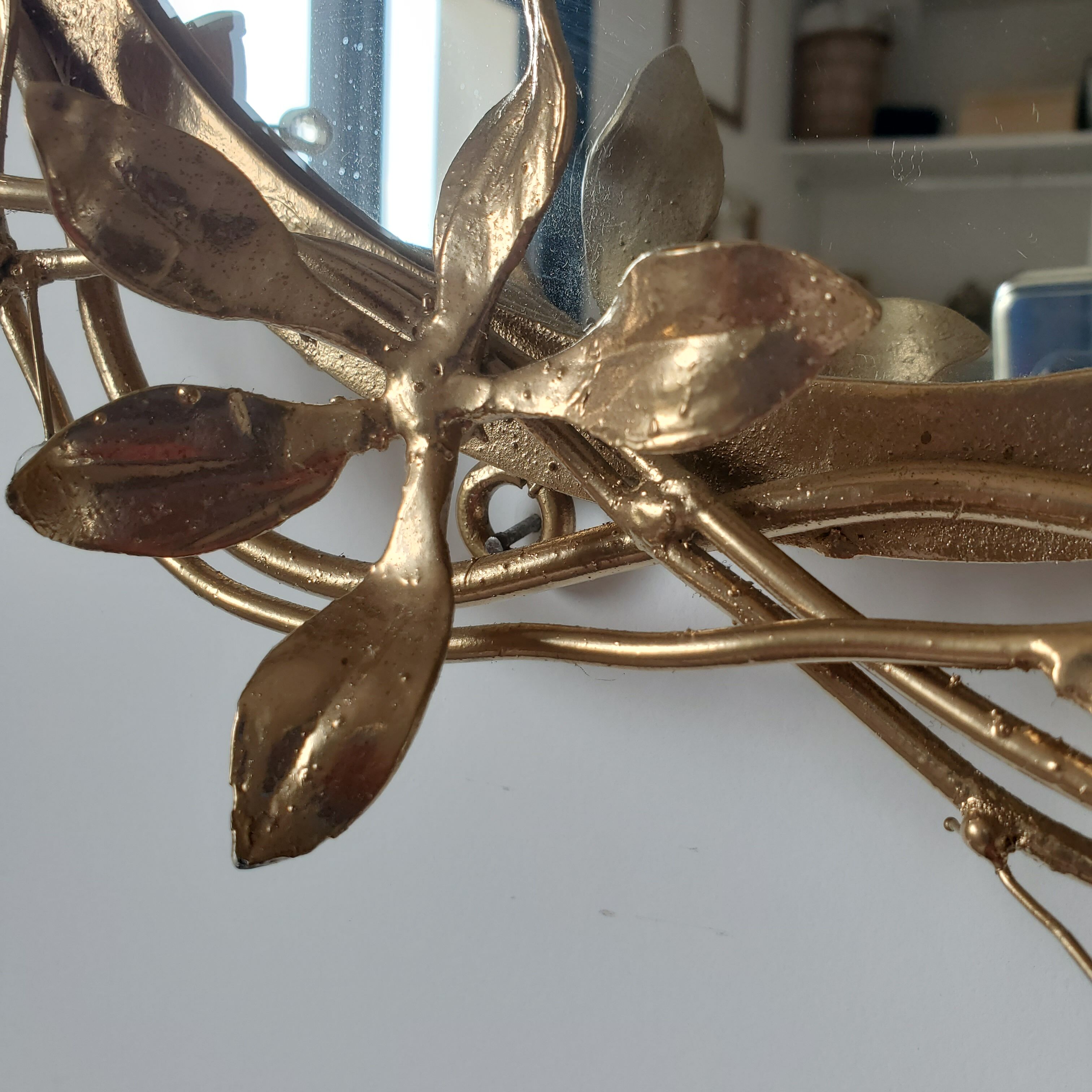 Round mirror in gilded wrought iron and leaves