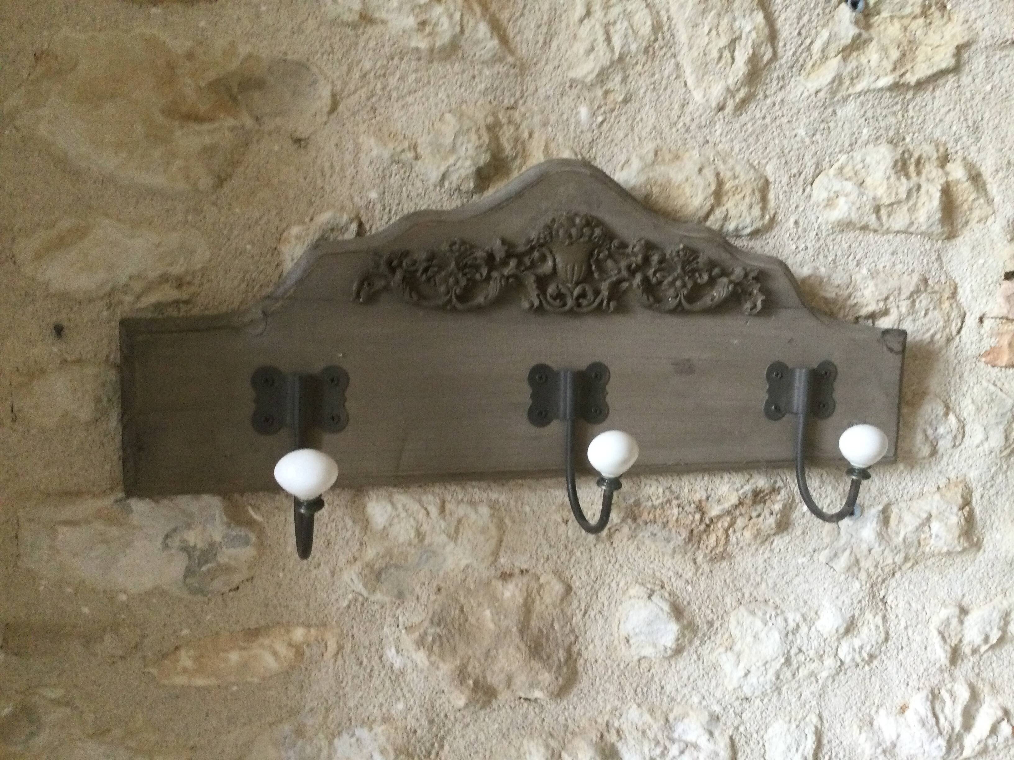 Wall-mounted wooden coat rack with 3 hooks.