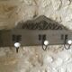 Wall-mounted wooden coat rack with 3 hooks.